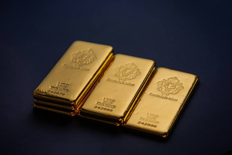 Three fine gold bars on a dark surface